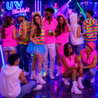 Groep feestende jongeren in fluorescerende kleding op een blacklightfeest met neonverlichting Groep feestende jongeren in fluorescerende kleding op een blacklightfeest met neonverlichting